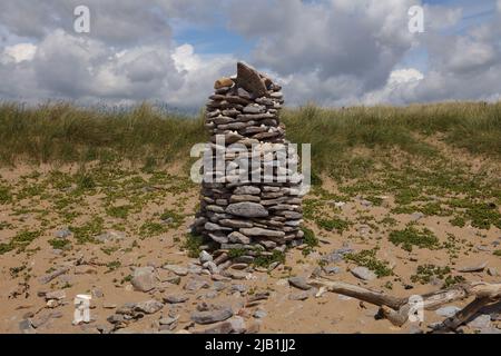 Eine schöne Säule aus Strandfelsen, die auf halbem Weg eine große Sanddüne in den Merthyr Mawr Sanddünen zu einer kegelförmigen Säule geformt wurde. Stockfoto