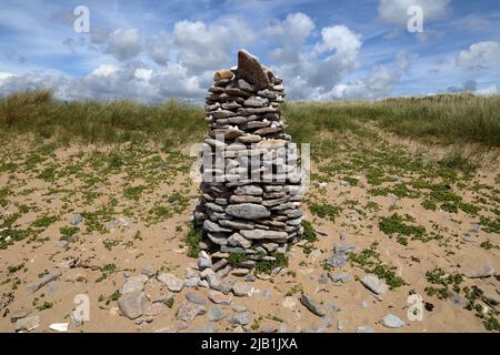 Eine schöne Säule aus Strandfelsen, die auf halbem Weg eine große Sanddüne in den Merthyr Mawr Sanddünen zu einer kegelförmigen Säule geformt wurde. Stockfoto