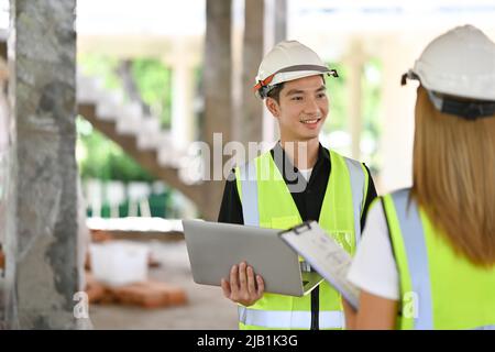 Leitiger Ingenieur, der mit den Inspektoren über das Bauprojekt spricht Stockfoto