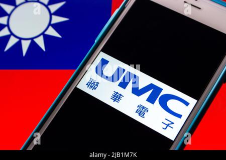 Kumamoto, JAPAN - Aug 16 2021 : Logo der UMC (United Microelectronics Corporation, Taiwans erstes Halbleiterunternehmen) auf dem iPhone auf taiwanesischer Flagge Stockfoto