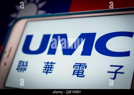 Kumamoto, JAPAN - Aug 16 2021 : Logo der UMC (United Microelectronics Corporation, Taiwans erstes Halbleiterunternehmen) auf dem iPhone auf taiwanesischer Flagge Stockfoto