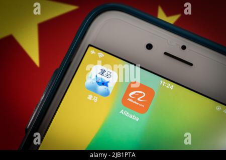 Kumamoto, JAPAN - Aug 26 2021 : Alibaba & Heme Fresh (Hema Xiansheng)-Symbole auf dem iPhone auf chinesischer Flagge bg. HEMA Fresh ist die Supermarktkette von Alibaba Stockfoto