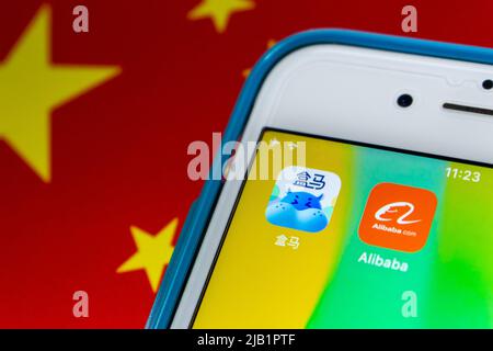 Kumamoto, JAPAN - Aug 26 2021 : Alibaba & Heme Fresh (Hema Xiansheng)-Symbole auf dem iPhone auf chinesischer Flagge bg. HEMA Fresh ist die Supermarktkette von Alibaba Stockfoto