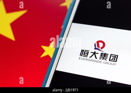 Kumamoto, JAPAN - Sep 17 2021 : Logo der Evergrande Group (The Evergrande Real Estate Group), Chinas führender Immobilienentwickler, mit chinesischer Flagge Stockfoto