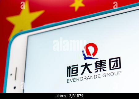 Kumamoto, JAPAN - Sep 17 2021 : Logo der Evergrande Group (The Evergrande Real Estate Group), Chinas führender Immobilienentwickler, mit chinesischer Flagge Stockfoto