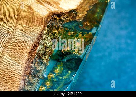 Tisch aus Epoxidharz mit transparenten Einsätzen und Holzsockel. Natursteine, gefüllt mit Epoxidharz in einer hölzernen Arbeitsplatte. Handgefertigte Designermöbel Stockfoto