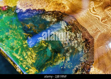 Tisch aus Epoxidharz mit transparenten Einsätzen und Holzsockel. Stockfoto