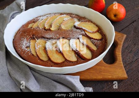 Schokoladenbrownie mit einer Birne in einer Backform. Essen sammeln Stil. Herbsthintergrund. Zutaten für die Zubereitung Stockfoto