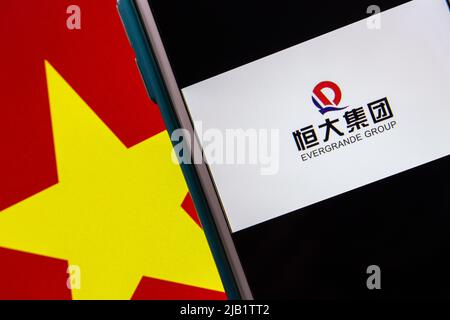 Kumamoto, JAPAN - Sep 24 2021 : Logo der Evergrande Real Estate Group, Chinas 2. größter Immobilienentwickler, auf iPhone auf vietnamesischer Flagge. Stockfoto