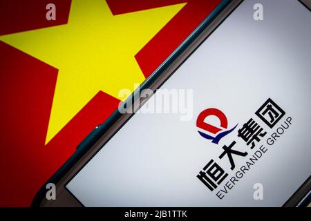 Kumamoto, JAPAN - Sep 24 2021 : Logo der Evergrande Group, Chinas führendem Immobilienentwickler, auf iPhone auf vietnamesischer Flagge in dunkler Stimmung Stockfoto