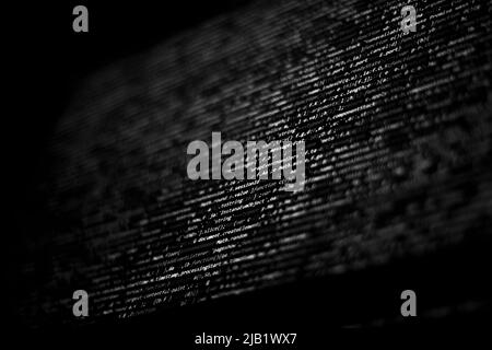 Schwarz-weißer Code-Hintergrund. javascript-Code auf dem Computerbildschirm Stockfoto