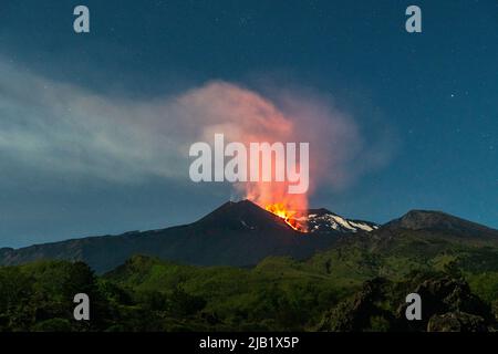 Lava, die aus dem südöstlichen Krater des Ätna, Sizilien, Italien, bei Nacht zu sehen ist. Anfang Mai 2022 wurde in diesem Krater eine neue Spalte eröffnet, die seitdem kontinuierlich aktiv ist. Der Ätna (3357m) ist einer der aktivsten Vulkane der Welt und der höchste in Europa Stockfoto