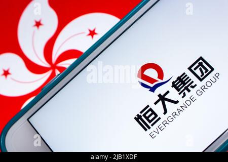 Logo der Evergrande Group (Evergrande Real Estate Group, vormals Hengda Group), Chinas führender Immobilienentwickler, auf dem iPhone unter der Flagge von Hongkong. Stockfoto