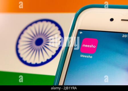 Indische Social E-Commerce Meesho App auf dem iPhone auf indischer Flagge. Es ist spezialisiert auf die Bereitstellung einer Online-Plattform für kleine Unternehmen, um Produkte zu verkaufen Stockfoto