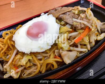 Japanische frittierte Nudeln Yakisoba mit Medamayaki-Platte (Spiegelei). Yakisoba ist ein Braten Ramen-Stil Weizennudeln mit mundgebratenen Porks & Gemüse Stockfoto