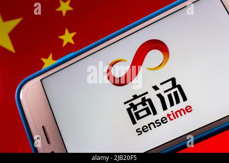 Kumamoto, JAPAN - Dez 14 2021 : das Logo von SenseTime, einem führenden Softwareunternehmen für künstliche Intelligenz mit Sitz in Hongkong, auf dem iPhone auf chinesischer Flagge. Stockfoto