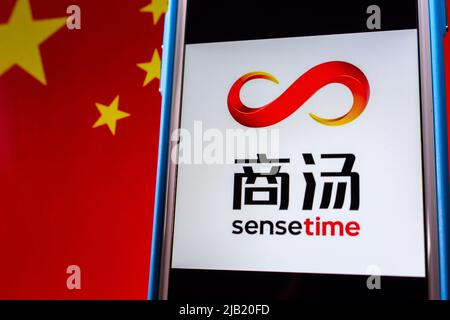 Kumamoto, JAPAN - Dez 14 2021 : das Logo von SenseTime, einem führenden Softwareunternehmen für künstliche Intelligenz mit Sitz in Hongkong, auf dem iPhone auf chinesischer Flagge. Stockfoto