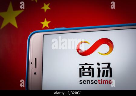 Kumamoto, JAPAN - Dez 14 2021: Logo von SenseTime, einem in Hongkong ansässigen Softwareunternehmen für künstliche Intelligenz, auf dem iPhone auf chinesischer Flagge in dunkler Stimmung Stockfoto