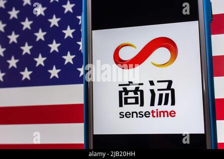 Kumamoto, JAPAN - Dez 14 2021 : das Logo von SenseTime, einem führenden Softwareunternehmen für künstliche Intelligenz mit Sitz in Hongkong, auf dem iPhone auf US-Flagge Stockfoto