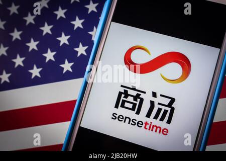 Kumamoto, JAPAN - Dez 14 2021 : Logo von SenseTime, einem führenden Softwareunternehmen für künstliche Intelligenz in Hongkong, auf dem iPhone auf US-Flagge in dunkler Stimmung Stockfoto