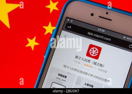 Digital Yuan App e-CNY im Xiaomi App Store im iPhone auf chinesischer Flagge. Der digitale Yuan ist eine Form der digitalen Währung der Zentralbank, CBDC Stockfoto