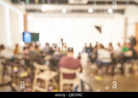 Verschwommener Hintergrund einer Geschäftskonferenz in einem hellen Raum. Gruppe von Menschen auf der Bühne, Projektpräsentation, öffentliche Aufführung. Hochwertige Fotos Stockfoto