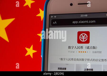 Digital Yuan App e-CNY im Xiaomi App Store im iPhone auf chinesischer Flagge. Der digitale Yuan ist eine Form der digitalen Währung der Zentralbank, CBDC Stockfoto