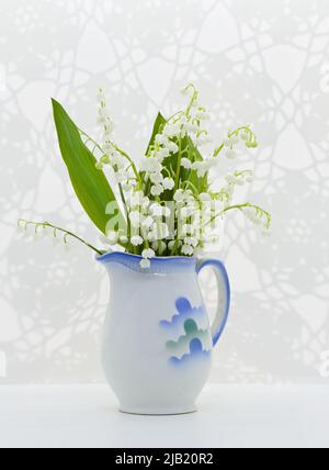 Ein Bouquet von Maiglöckchen blüht im dekorativen Keramiktopf Stockfoto