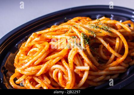 Japanische Naporitan Spaghetti zum Mitnehmen in einem Tablett. Naporitan (oder Napolitan) ist ein japanisches Nudelgericht. Es besteht aus Spaghetti, Tomatenketchup Stockfoto
