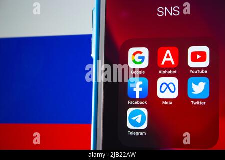 Beliebte Symbole für SNS oder IT-Unternehmen (Google, Alphabet inc., YouTube, Facebook, Meta Platform, Twitter und Telegram) auf einem iPhone mit russischer Flagge. Stockfoto