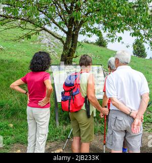 Gut behöhte Senioren wandern in idyllischer Natur Stockfoto