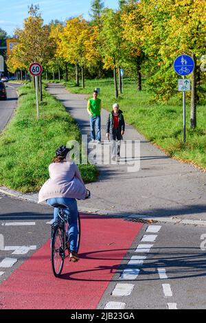 Radfahrer vom Radweg nach einem kombinierten Radfahren Straße und Fußweg mit Fußgängern Stockfoto