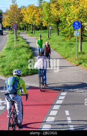 Radfahrer vom Radweg nach einem kombinierten Radfahren Straße und Fußweg mit Fußgängern Stockfoto