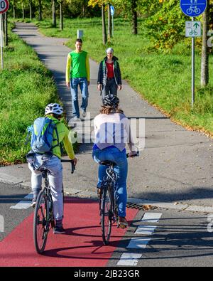 Radfahrer vom Radweg nach einem kombinierten Radfahren Straße und Fußweg mit Fußgängern Stockfoto