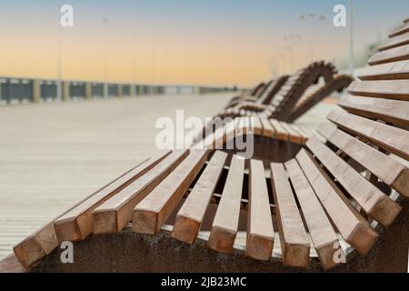 Sonnenliegen an einer leeren Meerpromenade im Vorgriff auf die Weihnachtszeit. Selektiver Fokus. Stockfoto