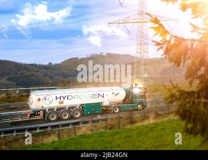 LKW mit Wasserstofftank, der auf einer Autobahn durch eine natürliche Landschaft fährt. Sonnenuntergang, die Sonne scheint tief. Die Konstruktion des Staplers ist wirtschaftlich rentabel. Stockfoto