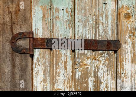 Türscharnier aus rostigem Metall. Türscharnier an einer Holzwand. Stockfoto