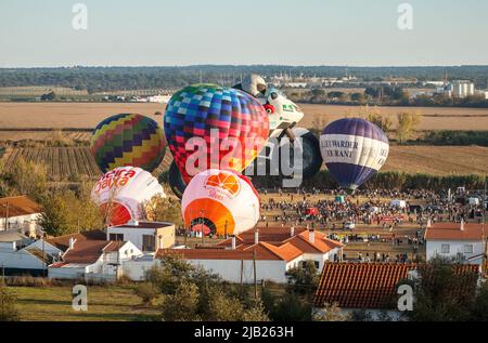 Coruche, Portugal - 13. November 2021: Blick auf Heißluftballons, die aufgeblasen und für den Start beim Coruche Ballooning Festival in Portugal vorbereitet werden Stockfoto