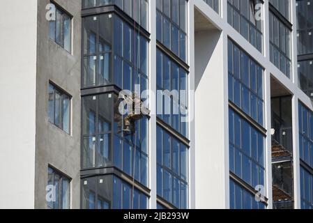 Bauarbeiter, der hoch außerhalb des Gebäudes arbeitet Stockfoto