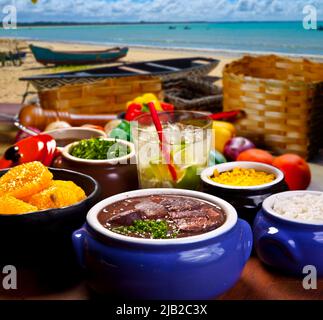 Traditionelles brasilianisches Essen, Feijoada genannt. Schwarze Bohnen mit Schweinefleisch, am Strand Stockfoto