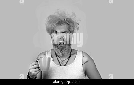 Bild von verschlafenen Hipster Mann 30er Jahre mit Borsten in Casual T-Shirt trinken Kaffee Stockfoto