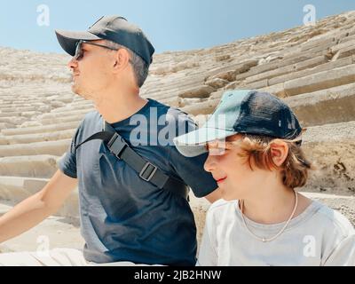 Der junge Vater Vater und sein Schuljunge Sohn Touristen besuchen alte antike kolosseum Amphitheater Ruinen an heißen Sommertagen Stockfoto