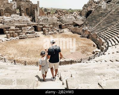 Der junge Vater Vater und sein Schuljunge Sohn Touristen besuchen alte antike kolosseum Amphitheater Ruinen an heißen Sommertagen Stockfoto