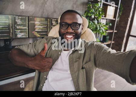 Selbstportrait eines attraktiven, fröhlichen und erfolgreichen Experten, der ein Projekt entwickelt, das auf dem Arbeitsplatz in Innenräumen auf dem Bummel zeigt Stockfoto