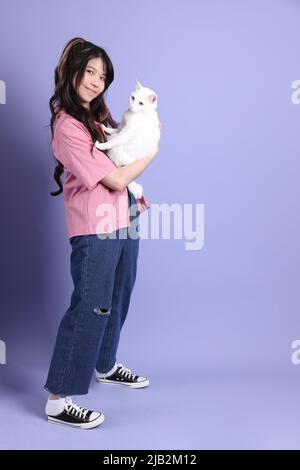 Die niedlichen jungen asiatischen Mädchen mit lässigen Kleidung auf dem lila Hintergrund stehen. Stockfoto