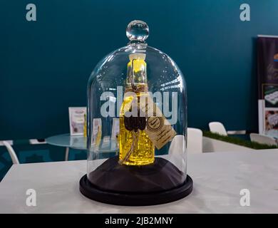 Kasan, Russland. 19.Mai 2022. Eine Flasche Sonnenblumenöl mit Stücken essbaren Goldes. Natürliches Sonnenblumenöl. Premium-Produkt Stockfoto