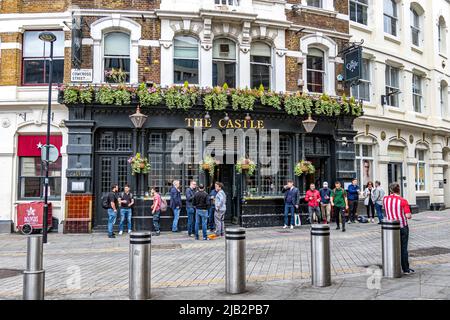 Leute, die einen Drink vor dem Castle Pub in der Cowcross Street, Farringdon, London EC1, genießen Stockfoto