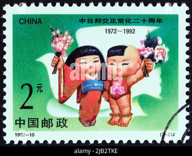 CHINA - UM 1992: Eine in China gedruckte Briefmarke zeigt das japanische Mädchen und den chinesischen Jungen, um 1992. Stockfoto