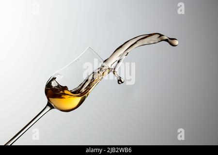 Das Getränk wird aus dem Glas verschüttet. Konzept des Themas Premium-Alkohol. Speicherplatz kopieren. Stockfoto