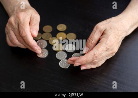 Ältere Frau zählt russische Rubel in Münzen, faltige weibliche Hände aus der Nähe. Konzept der Armut in Russland, Rentenzahlungen Stockfoto